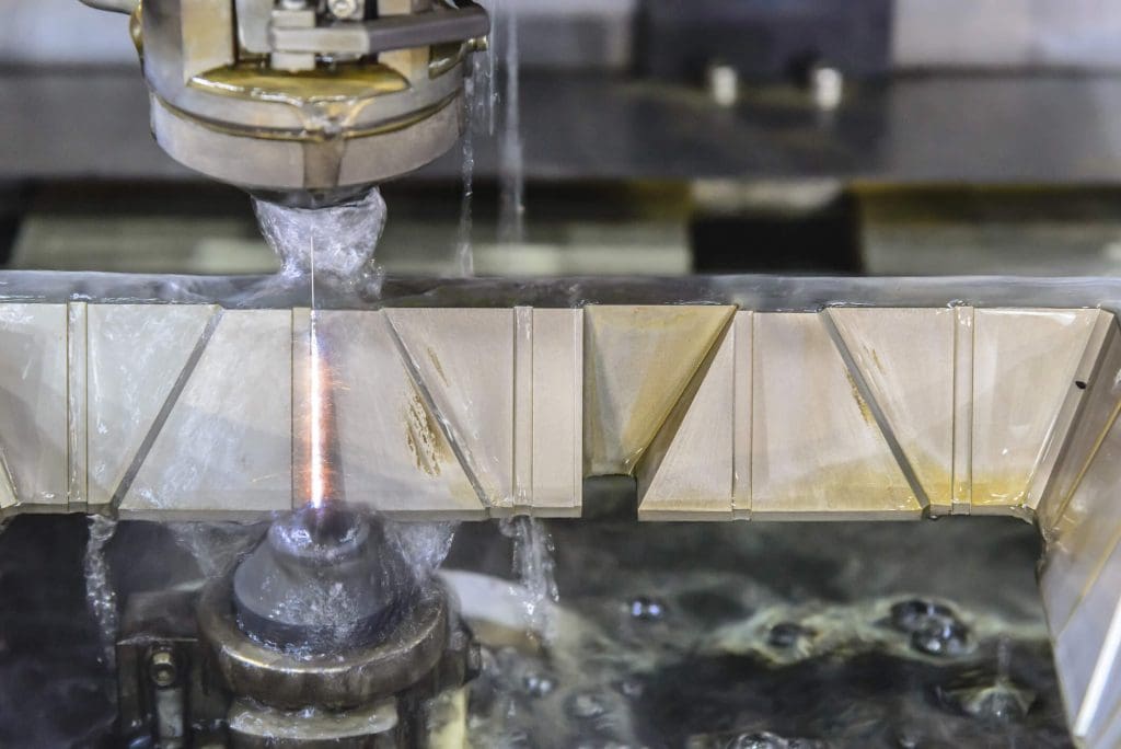 dreamstime_m_122719872 The CNC wire-edm machine cutting the metal plate for make the mold part. Hi-technology manufacturing process.