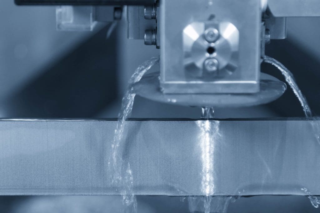 dreamstime_m_95059470 Close-up of the wire - EDM CNC machine while cutting the sample work pieces in light blue tone